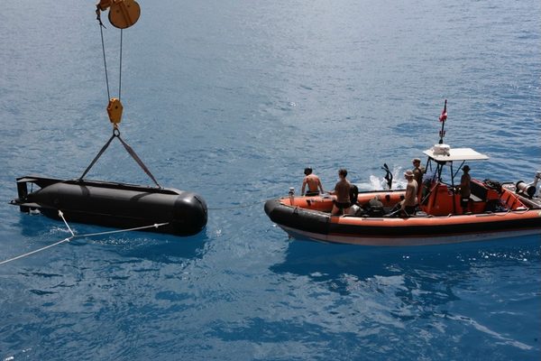 Submarine prop being lowered by crane beside RIB boat, Hawaii