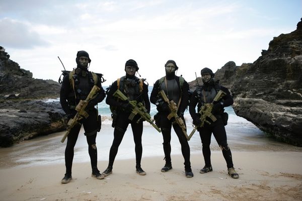 SEAL team silhouetted on beach at dusk, Hawaii