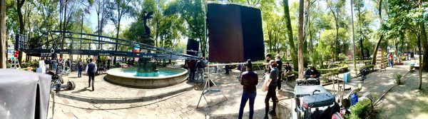 Panoramic view of camera crane and lighting rig on location at a plaza fountain, Mexico City