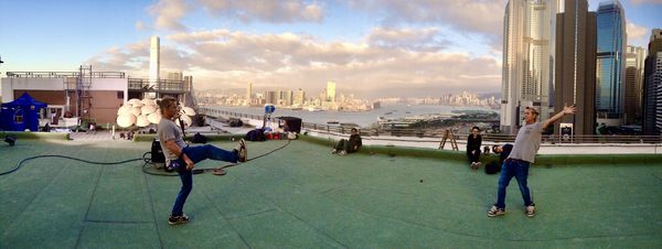 Panoramic view of crew on rooftop at sunset with Hong Kong skyline