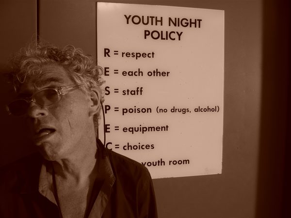 Sepia-toned portrait on set next to Youth Night Policy sign, Iceland