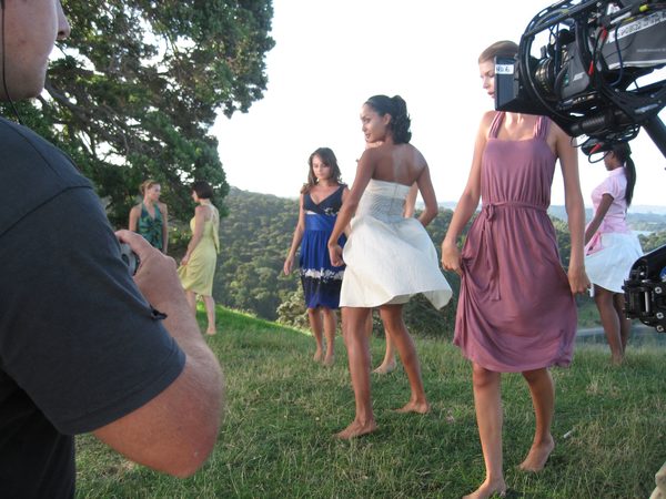 Models walking across a hilltop being filmed, North Island