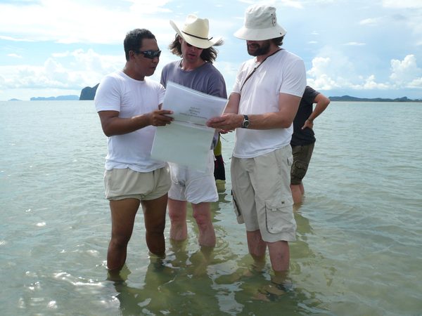 Crew reviewing the shot list standing in shallow water, Thailand