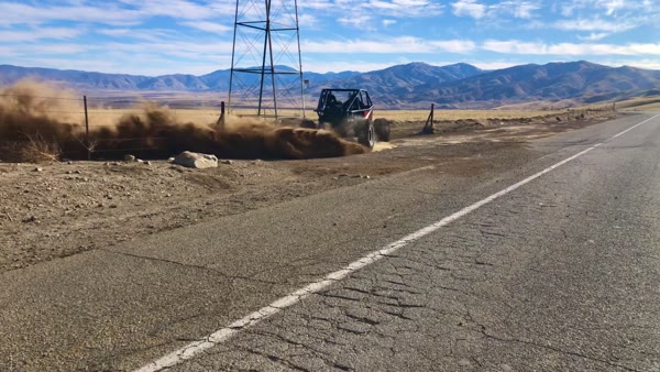 Off-road buggy kicking up dust on a desert road, Infinity