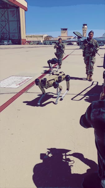 Armed airmen escorting quadruped robots on the flight line, U.S. Air Force