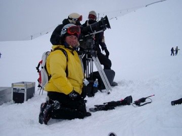 Crew kneeling in the snow beside camera equipment, Banff, Canada