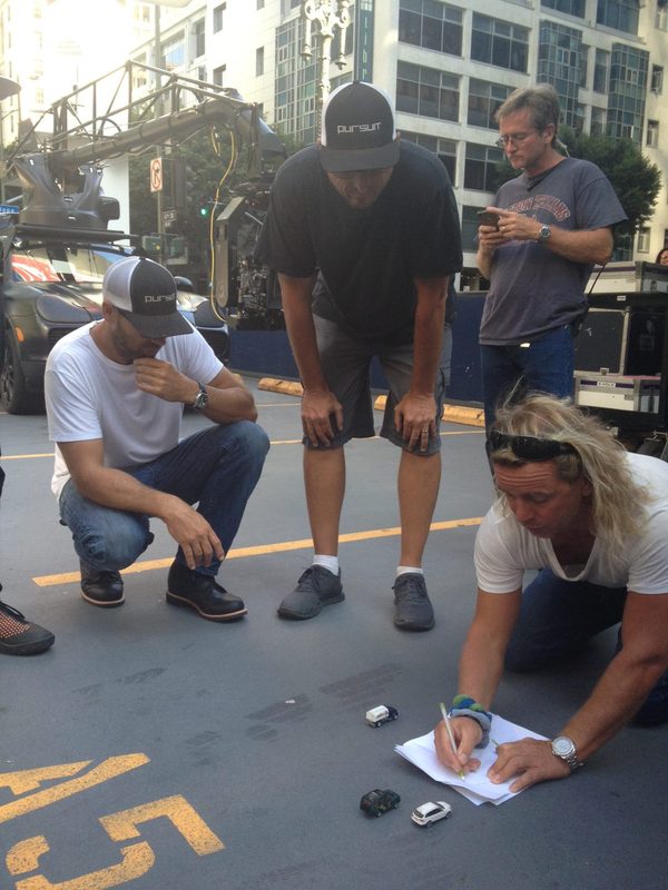 Crew blocking a car chase sequence with toy cars on a city street, Los Angeles