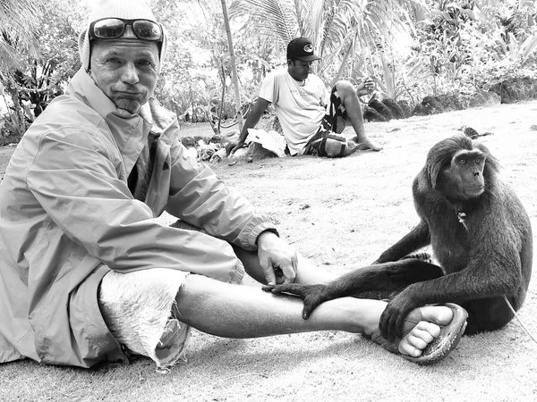 Bryan Altham on location with a crested macaque, Indonesia