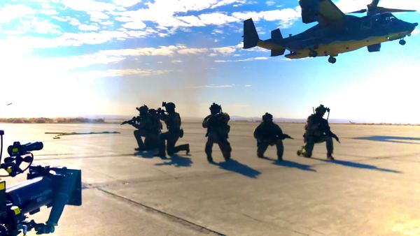 Airmen kneeling on the tarmac beneath a V-22 Osprey, Panavision camera in the foreground, U.S. Air Force