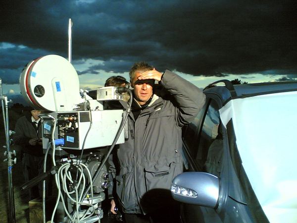 Camera crew with film camera rig under stormy sky, Mojave Desert