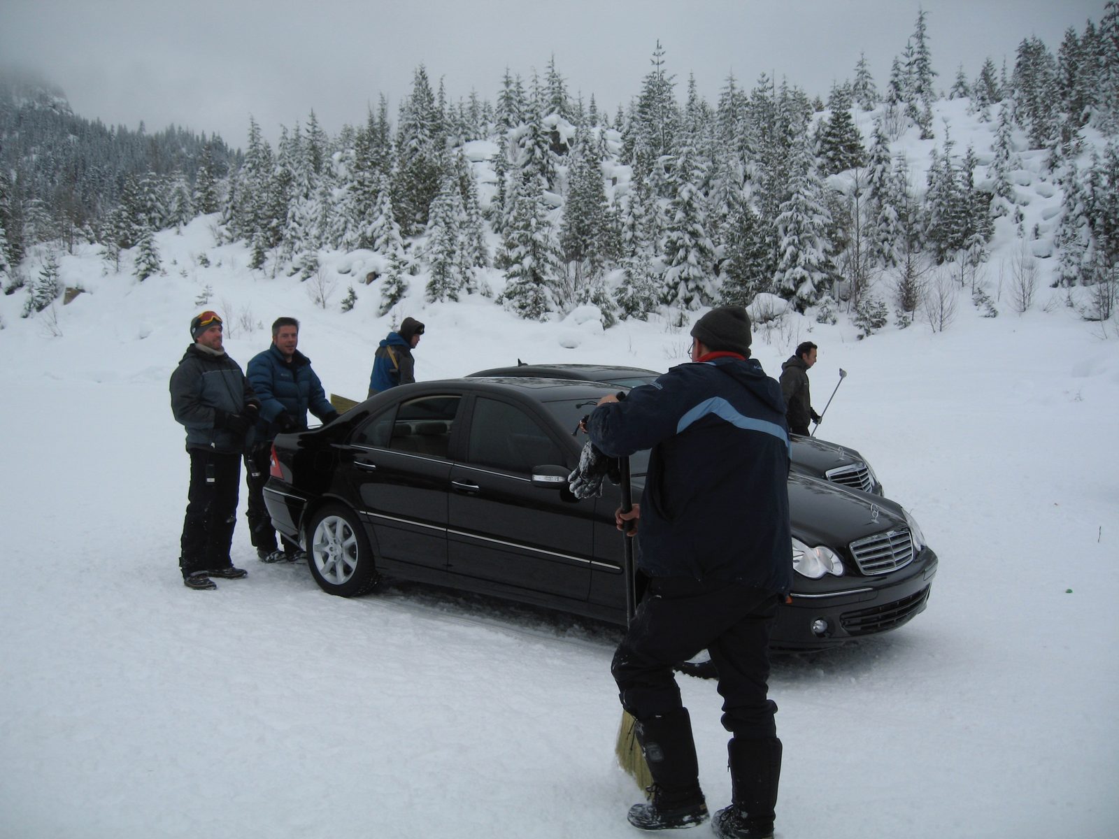 Crew gathered around Mercedes on snow, Canada