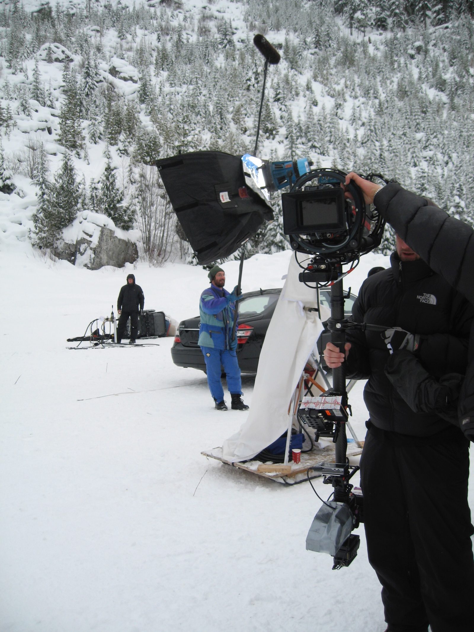 Camera unit filming Mercedes on snow-covered mountainside, Canada