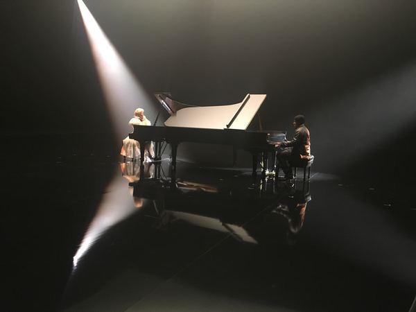 Lady Gaga and pianist on spotlit soundstage, Rolex