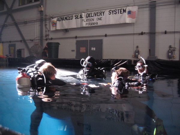 Navy SEAL trainees in indoor dive tank, Advanced SEAL Delivery System banner, Hawaii